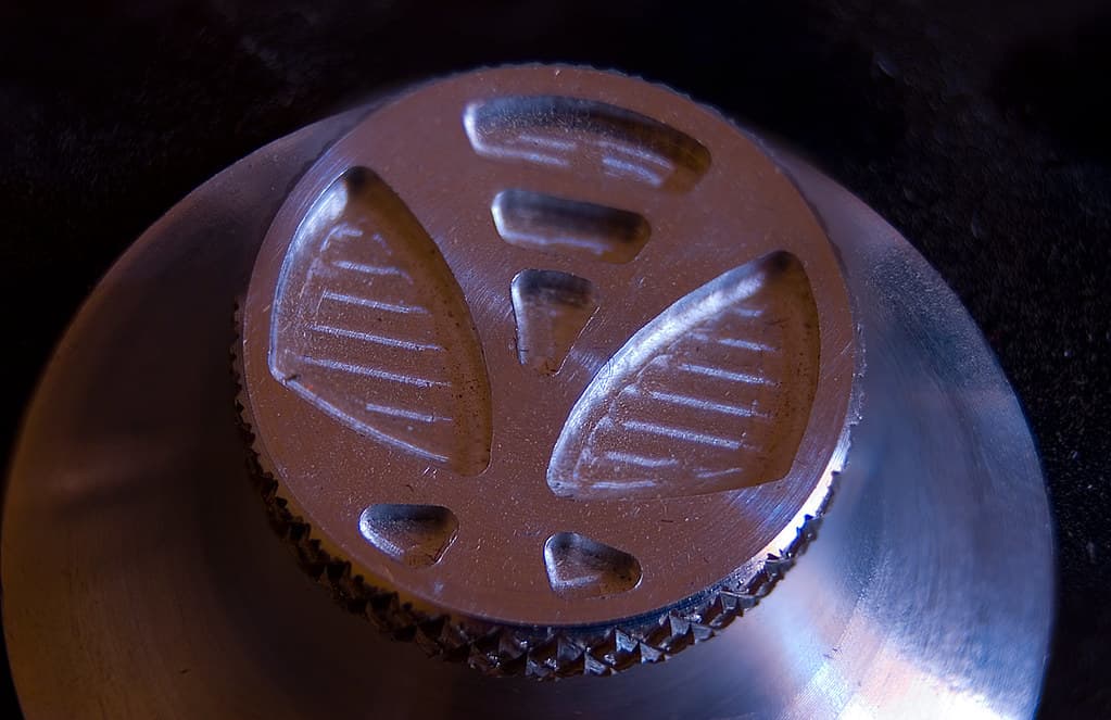 A close view of a milled metal control knob catching the light
