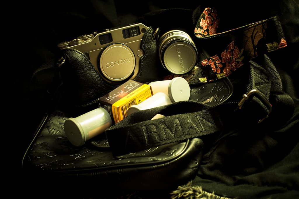 A compact silver and black camera resting on a surface in soft window light